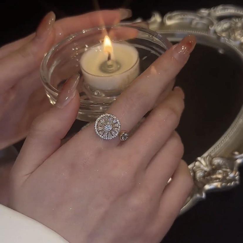 Women wearing a gold spinning ring while holding a candle